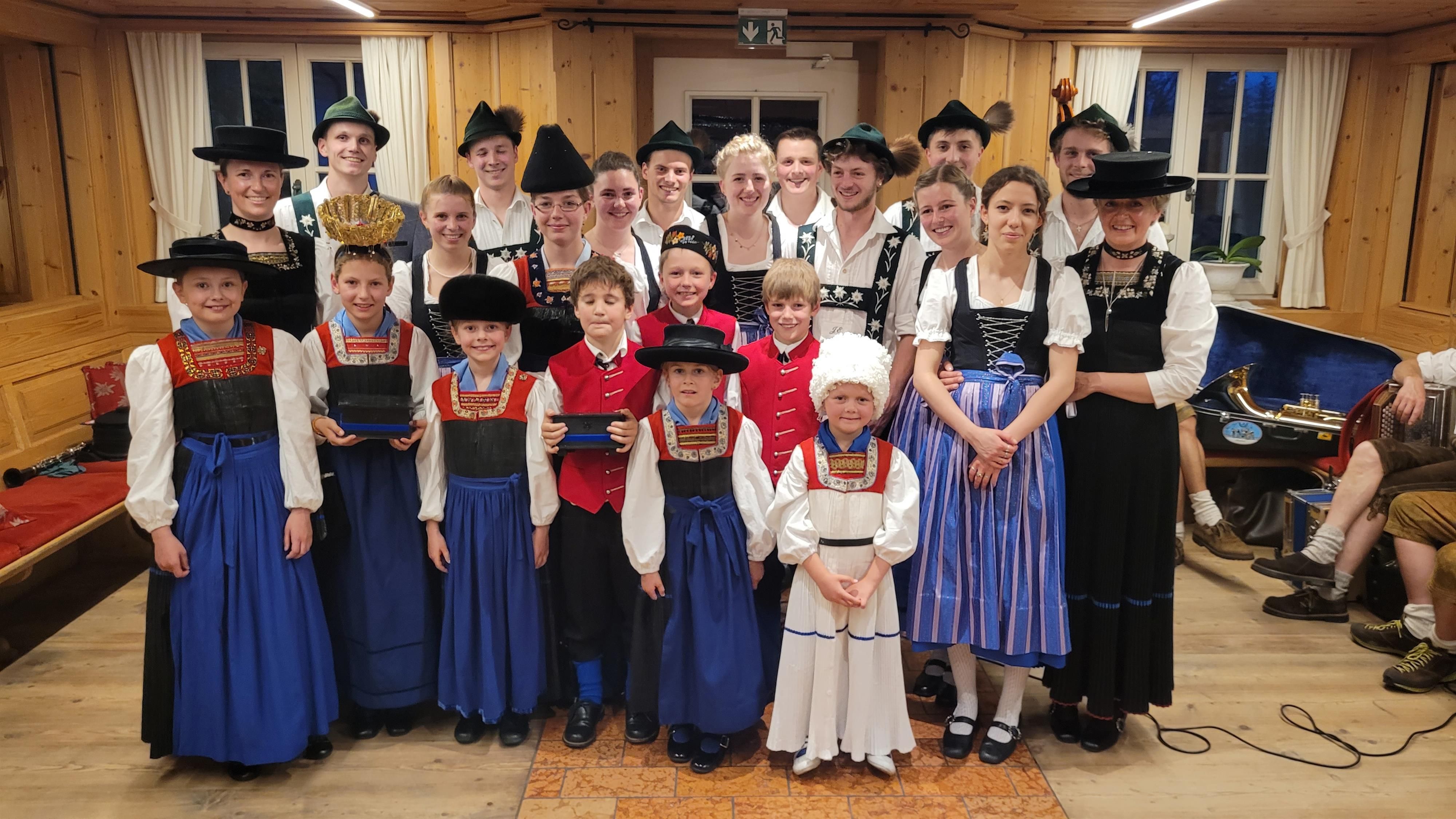 <p>Eine Gruppe von Erwachsenen und Kindern in traditioneller Tracht posiert für ein Foto.</p>