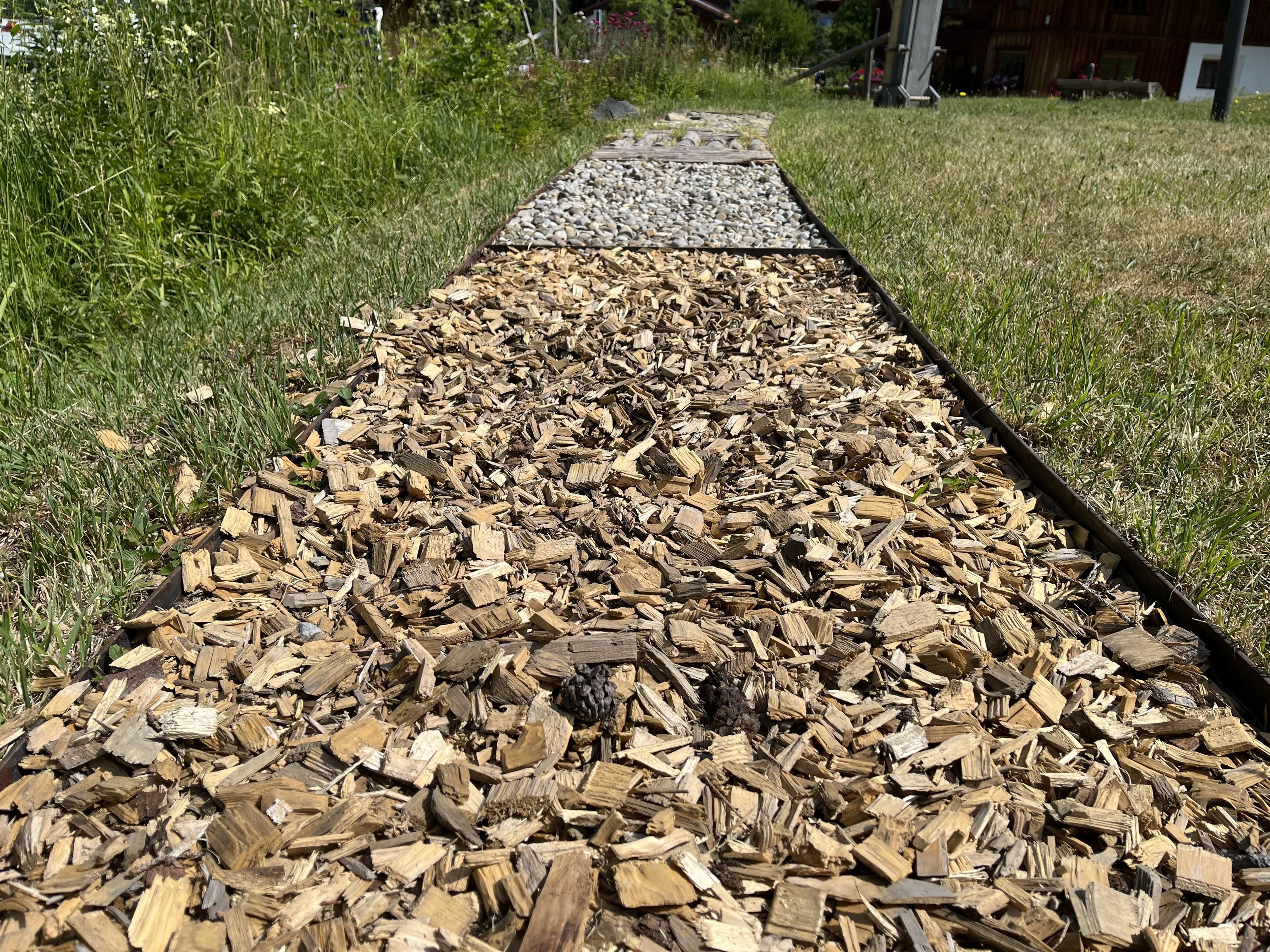 Der Barfußweg im Kurpark Ofterschwang aus Holzspäne und Kies.