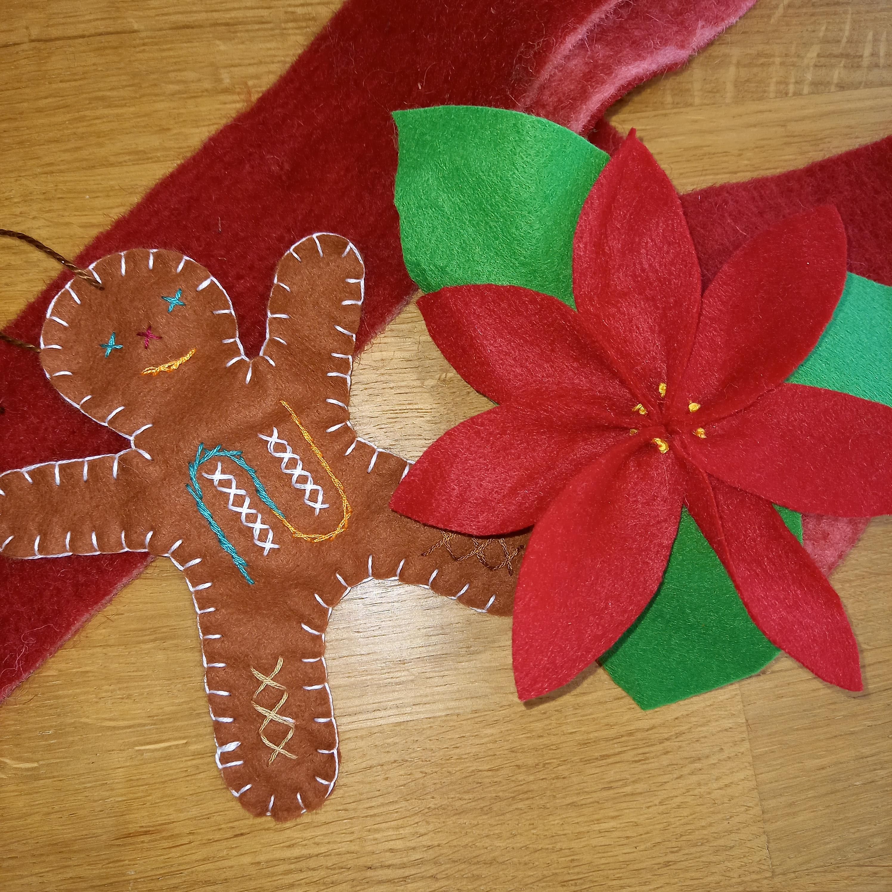 Links ein Lebkuchenmann: brauner Filz, verziert mit bunten Garnen, rechts ein Weihnachtsstern: roter und grüner Filz.