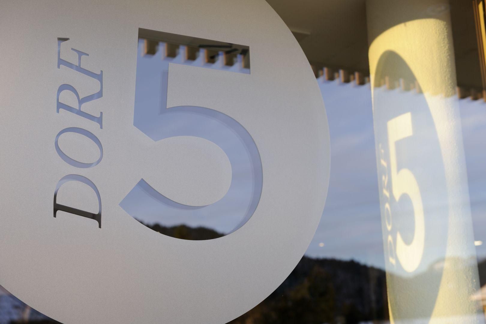 Detailaufnahme eines runden, weißen Schildes mit der Aufschrift "DORF 5".