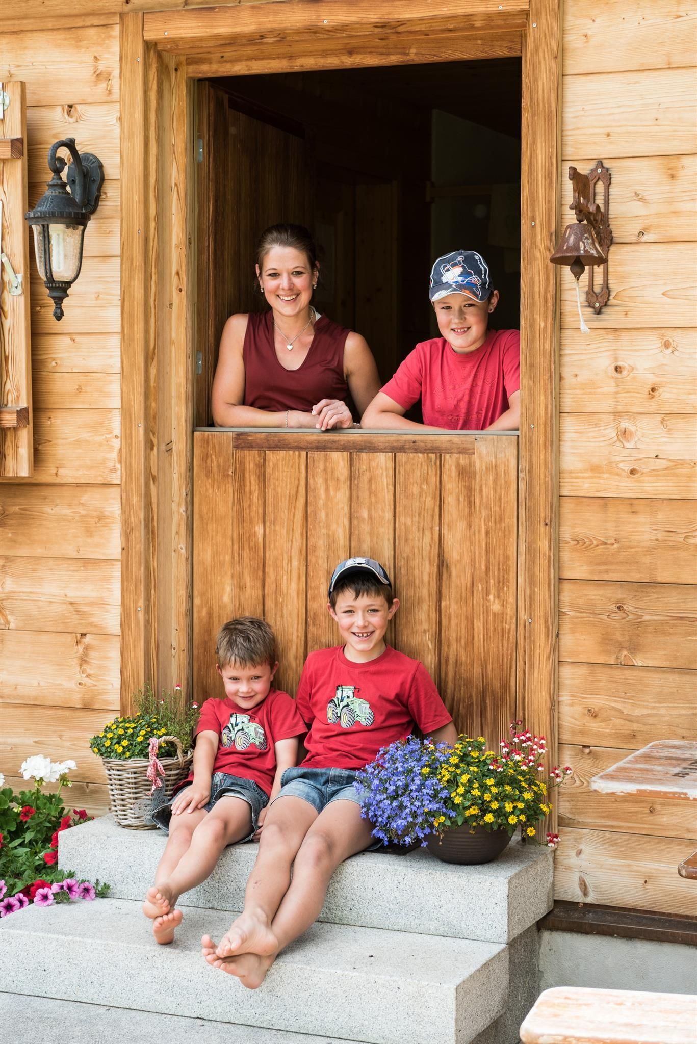 Die Betreiber Familie mit drei Kindern steht vor der offenen Tür der Alpe Hörnle in Obermaiselstein.