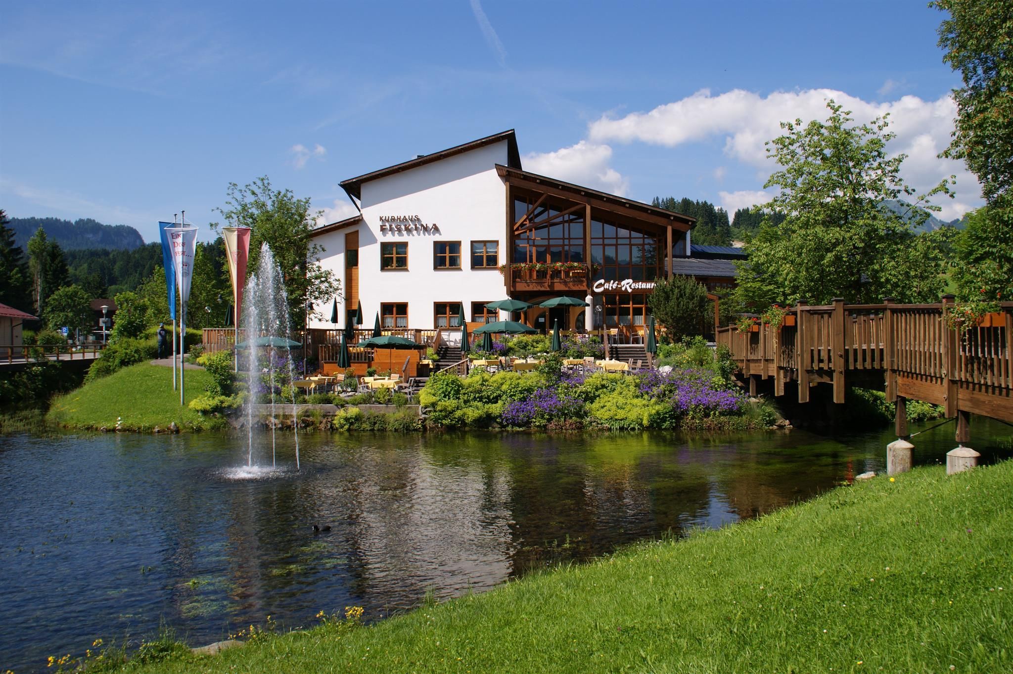 Im Vordergrund befindet sich ein kleiner See mit Springbrunnen, dahinter die Terrasse des Restaurants "Speisegalerie".