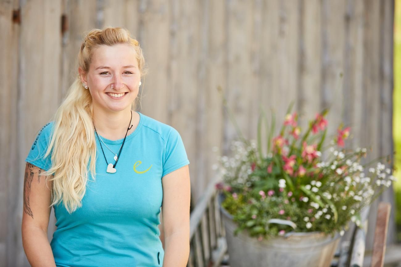 Porträt einer jungen Frau mit blondem, geflochtenem Haar.