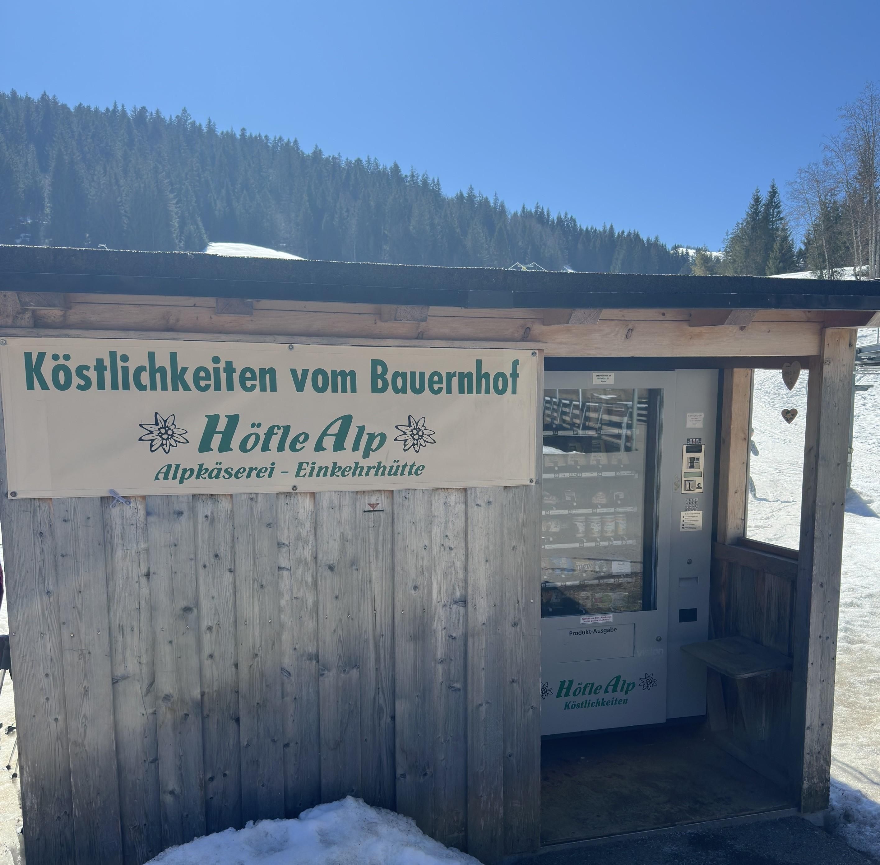 Heller, freundlicher Raum mit einem Verkaufsautomaten, dem Höfle Alp Automat.