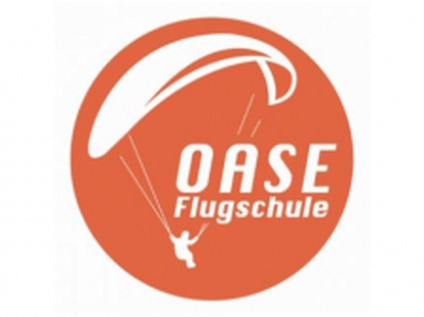 Logo OASE Flugschule: Orangefarbener Kreis, weißer Gleitschirmflieger, Schriftzug "OASE Flugschule".
