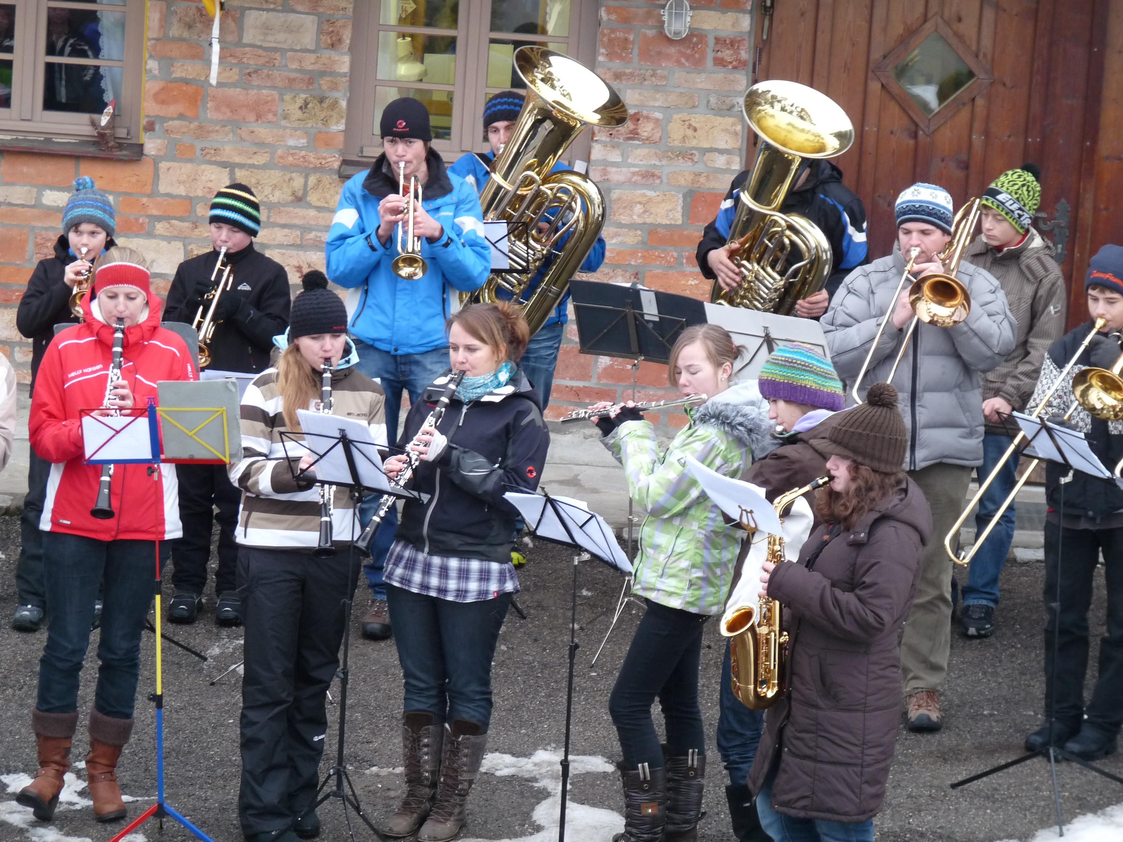 Einige Mitglieder des Jugendblasorchesters spielen in Fischen am Tag vor Silvester, alle tragen dicke Jacken.