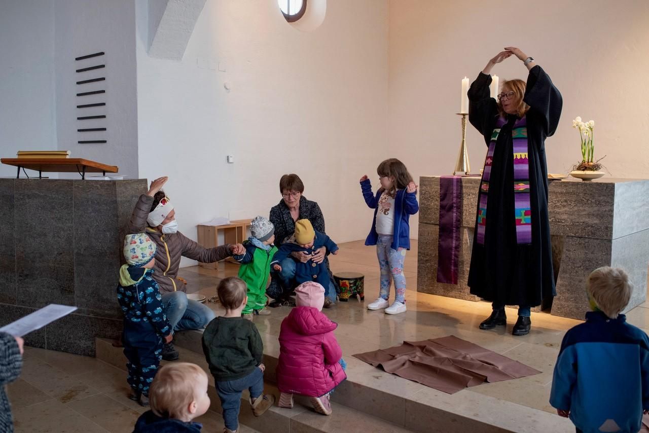 Während des Gottesdienstes: die Pfarrerin macht eine Figur vor, die Kleinkinder versuchen sie nachzuahmen.