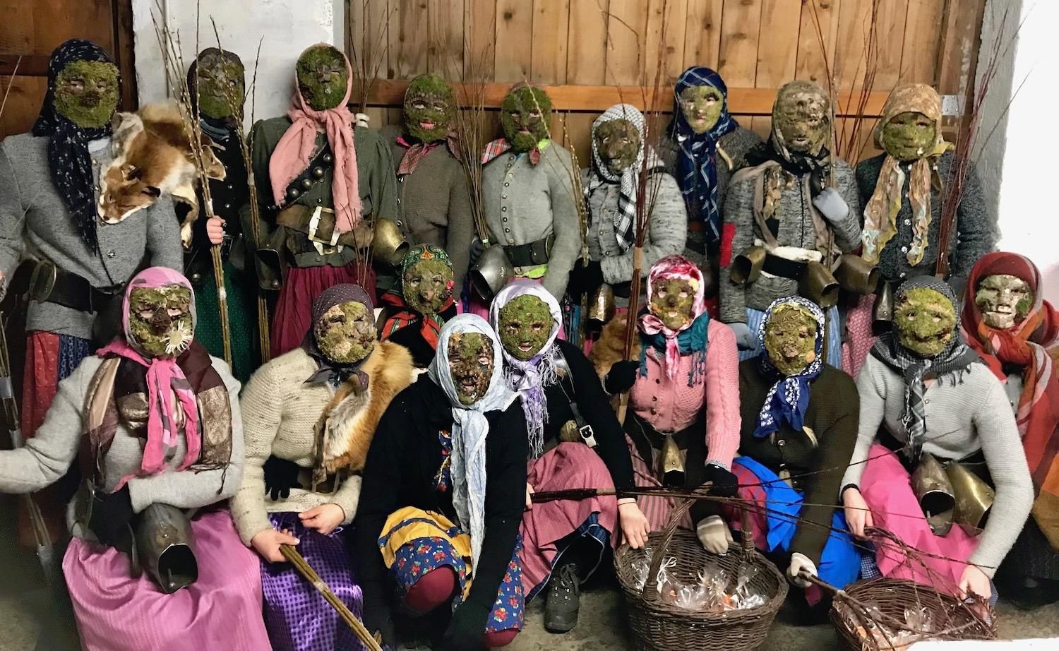 Eine Gruppe von Bärbele aus Ofterschwang, in traditionellen Trachten und Masken, posiert für ein Foto.