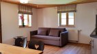 Wohnbereich mit Sofa und Küchenzeile, © Ferienwohnung Bader - Bolsterlang