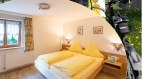 Schlafzimmer mit höherem Bett, © Ferienwohnungen Plangger