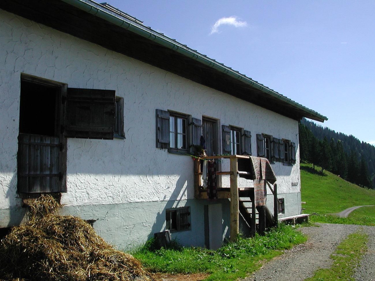 Alpe Spicherhalde – eine Berghütte mit weißer Fassade, braunen Holztüren und Fensterläden.