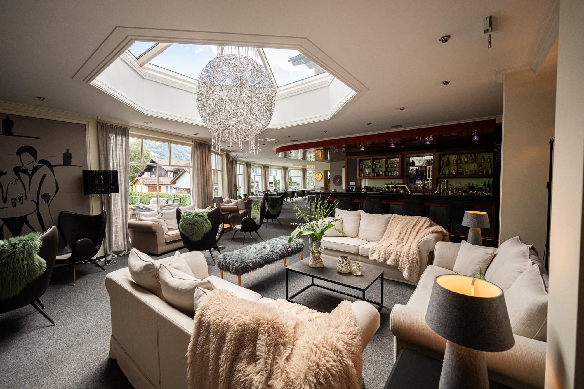 In dem Raum stehen drei Sofas mit Decken und Kissen, in der Decke befindet sich eine Glaskuppel.