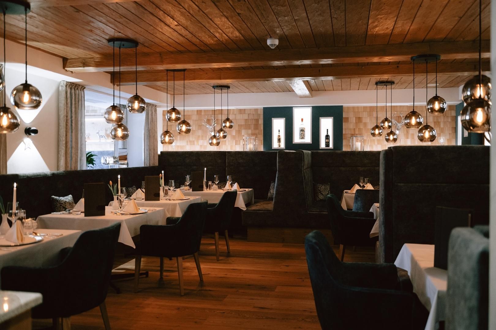 In der Bauernstube stehen Stühle in der Farbe dunkelgrün, auf den Tischen liegen weiße Tischdecken.