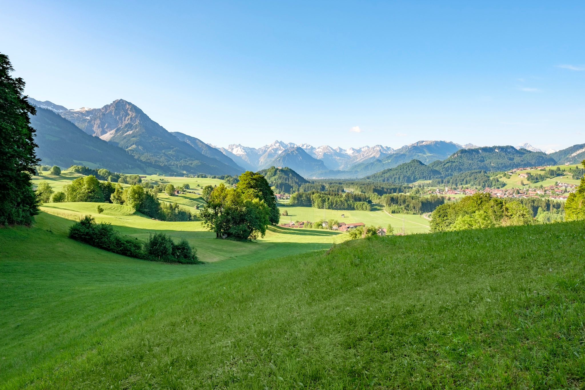 Blick vom Malerwinkel auf die sanfthügelige Tallandschaft bei Fischen und Alpenkette im Hintergrund