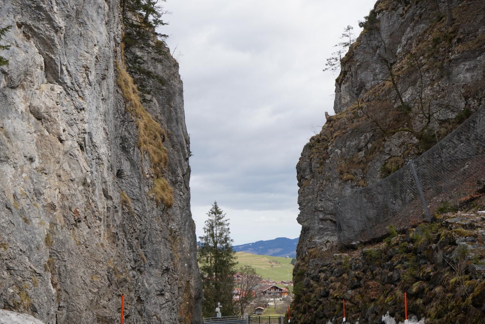 Links und rechts sind hohe Felsen, in der Mitte Blick auf Ried bei Obermaiselstein